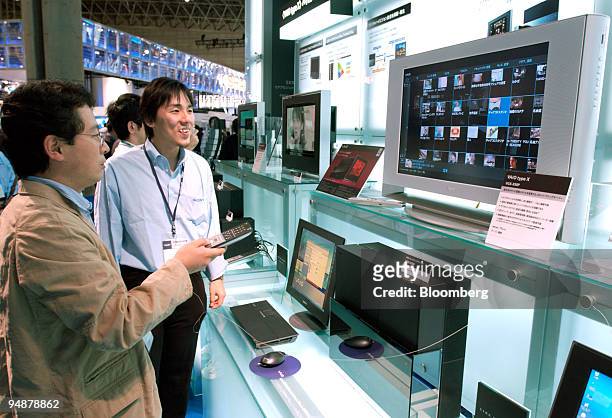 Trade show attendees look at new Sony Corp. Flat screen displays Tuesday, October 5, 2004 at CEATEC in Tokyo, Japan. Sony Corp., Toshiba Corp. And...