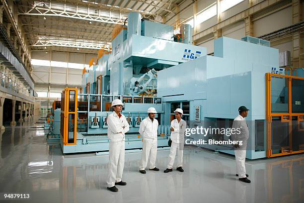 Employees stand in front of the press facility during the opening of phase one operations at the new Honda Siel Cars India Ltd. Plant in Tapukara,...