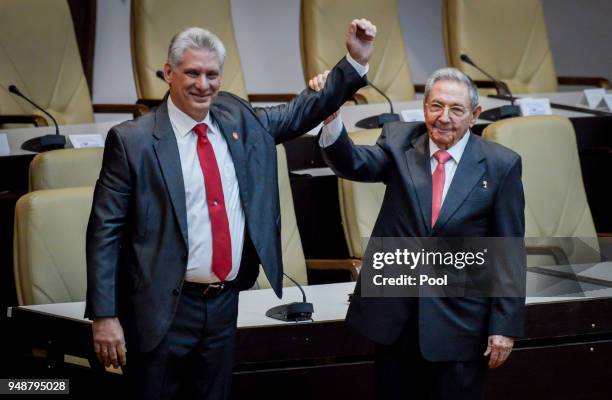 Former Cuban President Raul Castro raises the arm of newly elected Cuban President Miguel Diaz-Canel during the National Assembly at Convention...