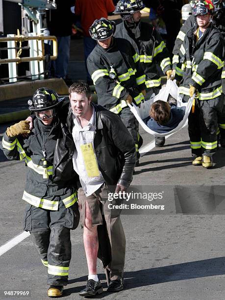 Victims" of a simulated explosion aboard the ferry Evergreen State are help off the boat by Seattle Fire Department personnel at Coleman Dock in...