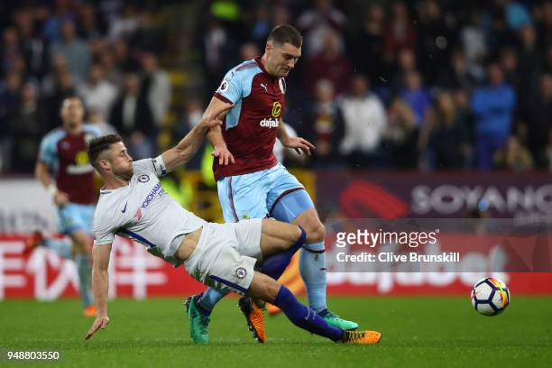 Gary Cahill of Chelsea tackles Sam Vokes of Burnley during the Premier League match between Burnley and Chelsea at Turf Moor on April 19, 2018 in...