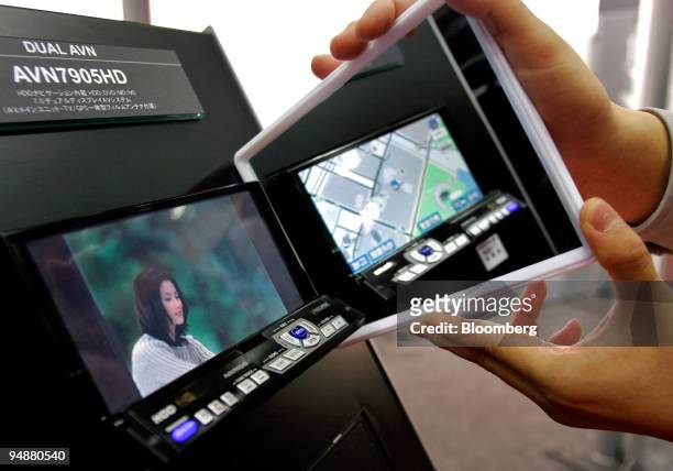 An employee holds up a mirror to show the different views available to the driver and passenger on the Dual AVN 7905 navigation/entertainment system...