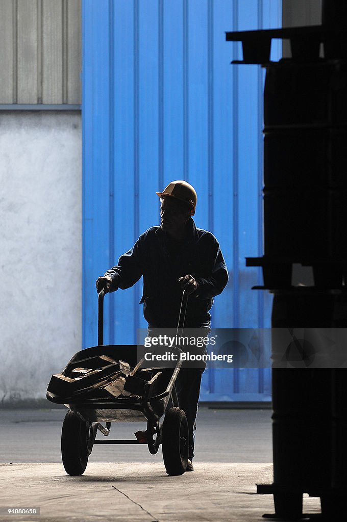 Employee Pougny Christian carries pieces of wood at Pica, a