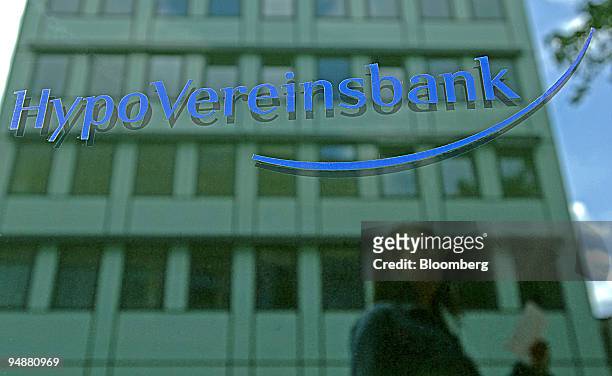 The reflection of a woman dropping off a bank deposit slip is seen on the window of a HypoVereinsbank or HVB branch in Frankfurt, Germany, Tuesday,...