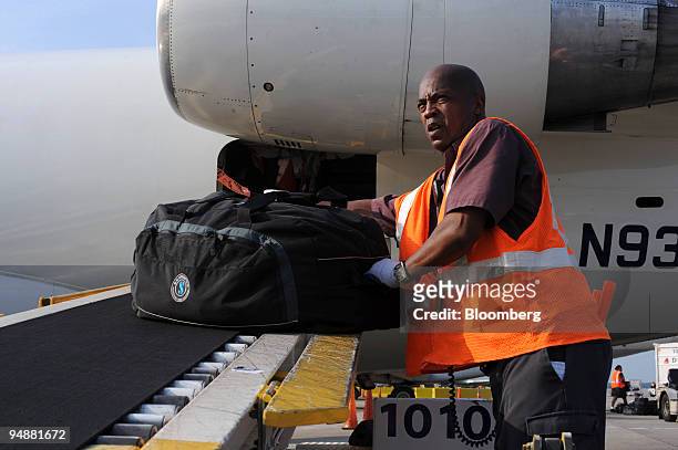 Gregory Pierce unloads baggage from an Atlantic Southeast Airlines airplane at Hartsfield-Jackson International Airport in Atlanta, Georgia, U.S., on...