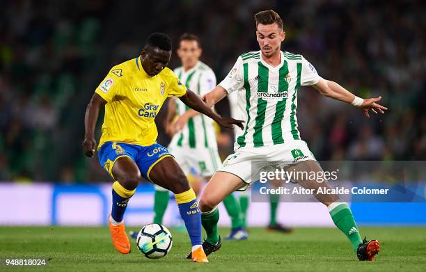 Fabian Ruiz of Real Betis Balompie competes for the ball with Oghenekaro Peter Etebo of Union Deportiva Las Palmas during the La Liga match between...