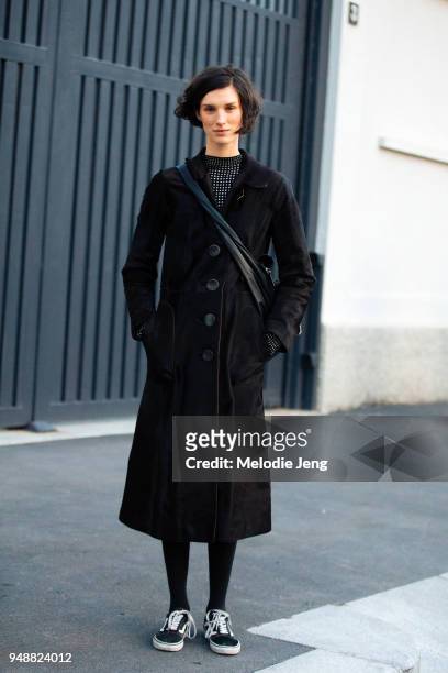 Dutch model Marte Mei Van Haaster wears a long black coat with buttons and black Vans sneakers during Milan Fashion Week Fall/Winter 2018/19 on...