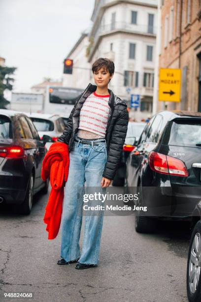 Model Victoria Carrillo wears a black down puffer jacket, a Unif cropped top, obermeyer underwear, and blue jeans during Milan Fashion Week...