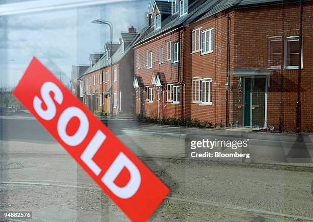 Sold sign hangs in the window and reflects new build property on the Bryant Homes Bridgefield development at Ashford, Kent, U.K., on Friday, March 7,...