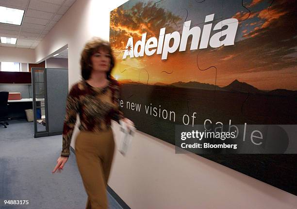 Woman walks past an Adelphia sign inside their headquarters in Greenwood Village, Colorado, February 25, 2004. Adelphia Communications Corp., whose...