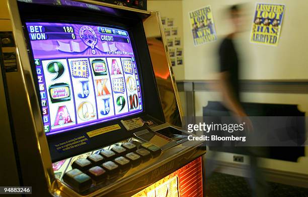 Patron passes one of the poker/slot machines in Belfield Hotel's gaming room in Sydney's western suburbs November 30, 2003.