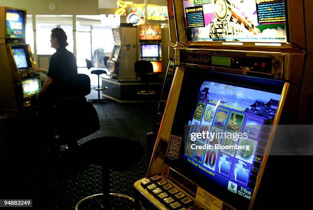 Gambler trys his luck on one of the poker/slot machines in Belfield Hotel's gaming room in Sydney's western suburbs November 30, 2003.