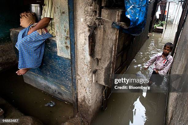 Boy walks out of his flooded house in Mumbai, India, on Tuesday, July 1, 2008. Train services and road traffic were disrupted yesterday in India's...