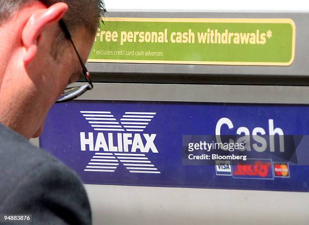 Customer uses an ATM cash machine at a branch of the Halifax in London, U.K., on Tuesday, June 24, 2008. Lloyds TBS Group Plc, the U.K.'s biggest...