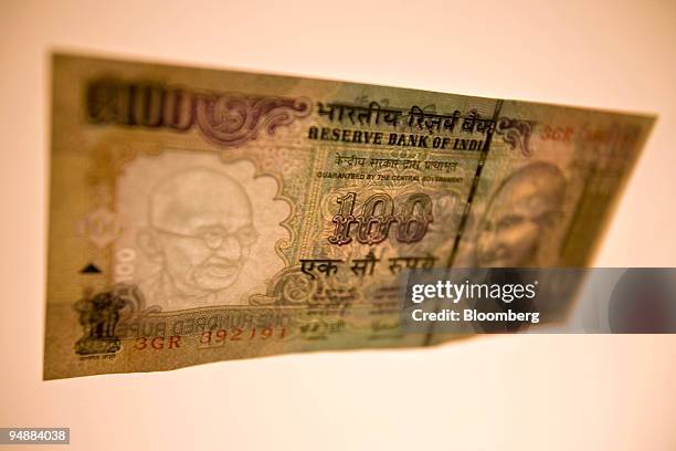 An Indian 100 rupee note is arranged for a photograph in Mumbai, India, on Monday, June 23, 2008. The rupee shows no signs of reversing its slide as...