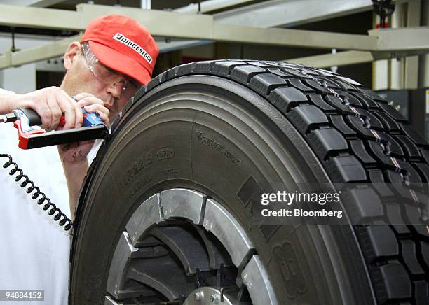 Bridgestone TRK Co. Employee retreads a tire at the company's Kazo plant in Kazo City, Saitama Prefecture, Japan, on Friday, June 20, 2008....