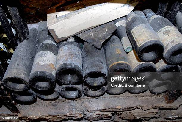 Old and dusty wine bottles sit in the cellar at the Clos Saint Jean vineyard, in the Burgundy village of Chassagne-Montrachet, France, on Tuesday,...