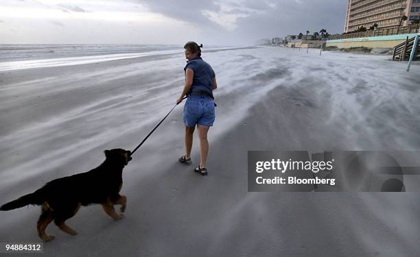 Teri Hutchins walks her dog Brutus on the beach early Monday morning Sept.ember 6, 2004 in Daytona Beach, Florida after Hurricane Frances passed...