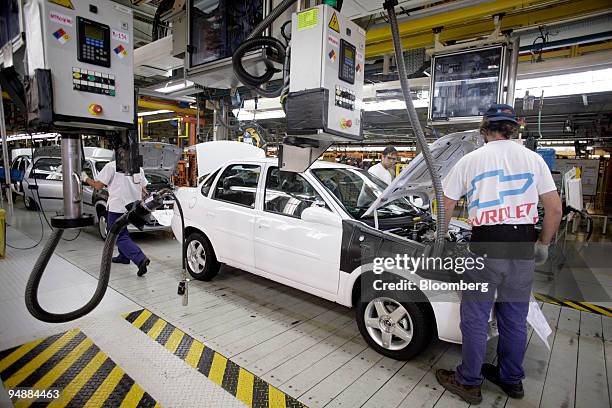 Workers inspect a finished Corsa at the General Motors manufacturing facility in Rosario, Argentina, on Thursday, March 6, 2008. The factory has an...