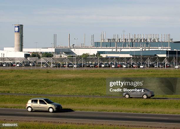 Cars pass a General Motors factory in Rosario, Argentina, on Thursday, March 6, 2008. The factory has an output of 30 cars per hour, and makes two...