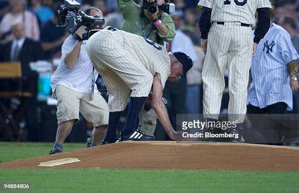 Don Larsen, former member of the New York Yankees and the only pitcher in baseball history to throw a perfect game in the World Series, gathers dirt...