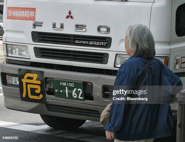Woman walks by a Mitsubishi Fuso Super Great commercial truck in Tokyo, Monday, May 23, 2005. Mitsubishi Motors Corp., Japan's fifth-largest carmaker...