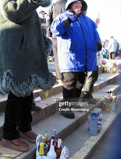 Vendors offer bootleg alcohol for sale at a market in central Warsaw Saturday, February 21, 2004. Rising living standards in Poland -- gross domestic...