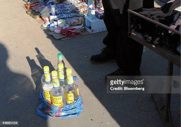 Vendor offers bootleg alcohol for sale at a market in central Warsaw Saturday, February 21, 2004. Rising living standards in Poland -- gross domestic...
