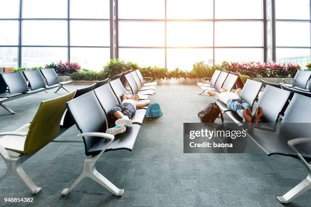 vader en zoon slapen bij vliegveld bank - jet lag stockfoto's en -beelden