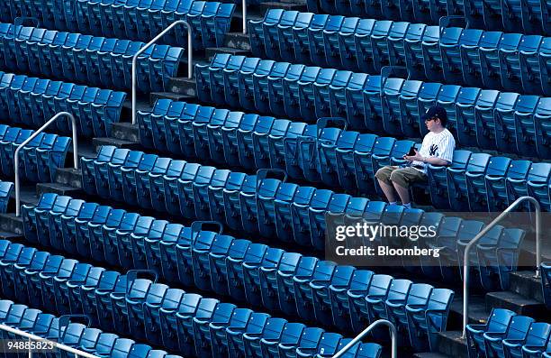 Fan sits alone in the upper deck seats at Yankee Stadium before a game between the Baltimore Orioles and New York Yankees in the Bronx borough of New...