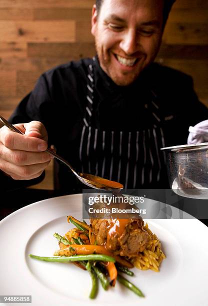 Chef Scott Conant finishes a boneless braised veal shank dish at his new Italian restaurant Scarpetta in the Meatpacking district of New York, U.S.,...