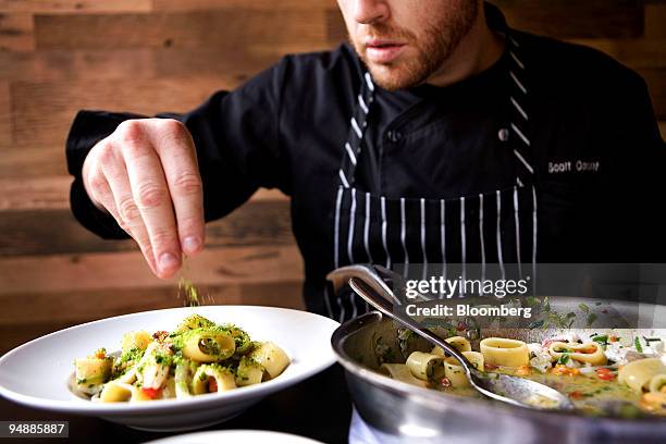 Chef Scott Conant finishes a calamarata pasta dish with minted bread crumbs at his new Italian restaurant Scarpetta in the Meatpacking district of...