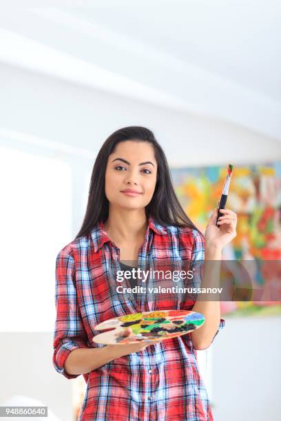 leende ung kvinna håller färgpalett och pensel - color palette bildbanksfoton och bilder