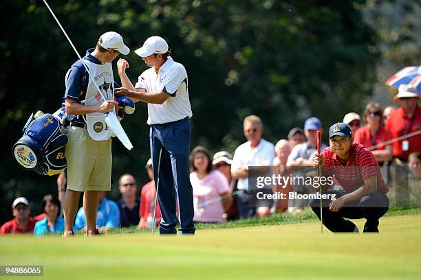 Anthony Kim of the U.S. Team, right, lines up a putt on the 2nd hole during a singles match against Sergio Garcia of the European team, second from...