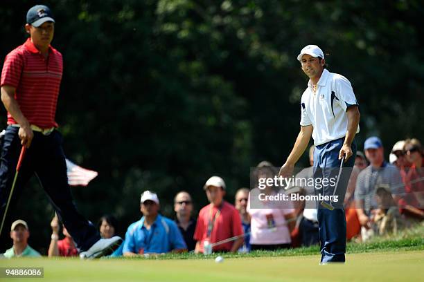 Sergio Garcia of the European team, right, reacts after putting 18 inches short of the 2nd hole during a singles match against Anthony Kim of the...