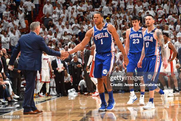 Brett Brown and Justin Anderson of the Philadelphia 76ers high five during the game against the Miami Heat in Game Three of Round One of the 2018 NBA...