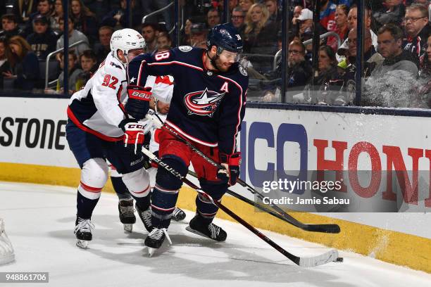 Evgeny Kuznetsov of the Washington Capitals knocks the puck away from Boone Jenner of the Columbus Blue Jackets during the first period in Game Four...