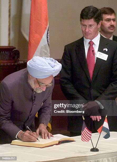 Manmohan Singh, left, Prime Minister of the Republic of India, signs a guest book as New York Stock Exchange CEO John Thain looks on, prior to a...