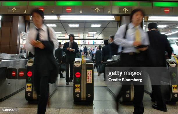 Japanese businessmen pass through the Japan Railways East wickets at Tokyo Station Thursday, May 19, 2005. Japanese stocks rose, with the Nikkei 225...