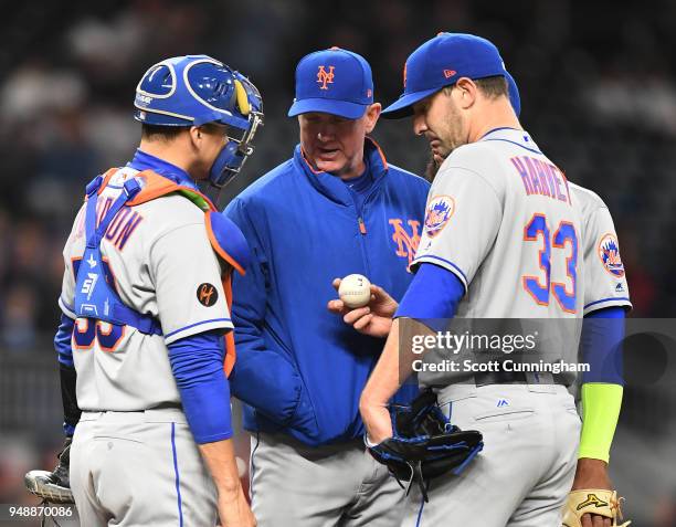 Pitcher Matt Harvey of the New York Mets meets with pitching coach Dave Eiland and catcher Jose Lobaton during the third inning against the Atlanta...