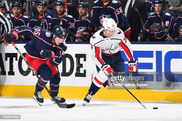 Lars Eller of the Washington Capitals skates the puck away from Markus Nutivaara of the Columbus Blue Jackets during the second period in Game Four...