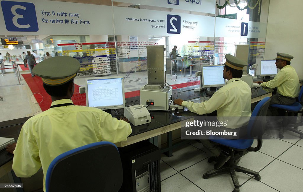 Delhi Metro Rail Corp. employees work at a ticket counter at the ...