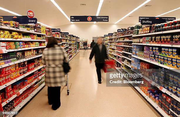 Customers walk down the aisles at Sainsbury's supermarket, in London Colney, U.K., on Friday, Feb. 29, 2008. U.K. Inflation probably reached the...