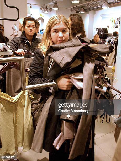 Shopper fills her arms with clothing from the Stella McCartney designer collection released today at H&M stores around the world, in Paris, France,...