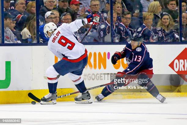 Dmitry Orlov of the Washington Capitals and Cam Atkinson of the Columbus Blue Jackets battle for control of the puck during the second period in Game...