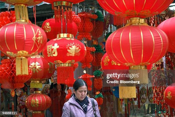 Woman walks past red lanterns for sale at a market in Chengdu, China, on Sunday, Jan. 27, 2008. The year of the Rat begins on Feb. 7, 2008.