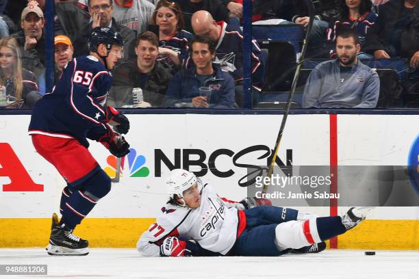 Oshie of the Washington Capitals falls to the ice while battling for the puck with Markus Nutivaara of the Columbus Blue Jackets during the third...