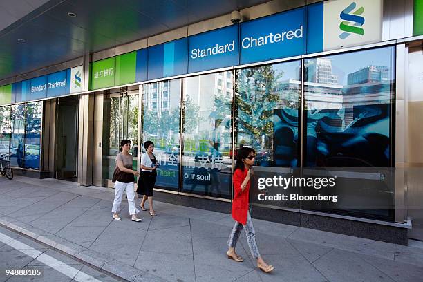 People walk past a Standard Charted Plc bank branch in Beijing, China, on Friday, Sept. 12, 2008. Standard Chartered Plc, the U.K. Bank that gains...