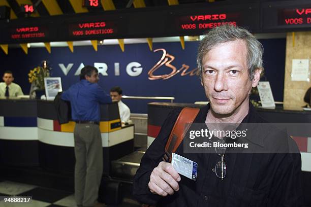 Brazilian movie director Hilton Kauffmann poses for a photograph with his his Varig frequent flyer pass after arriving home from trip at Congonhas...