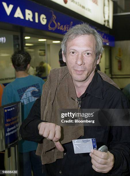 Brazilian movie director Hilton Kauffmann poses for a photograph with his his Varig frequent flyer pass after arriving home from trip at Congonhas...